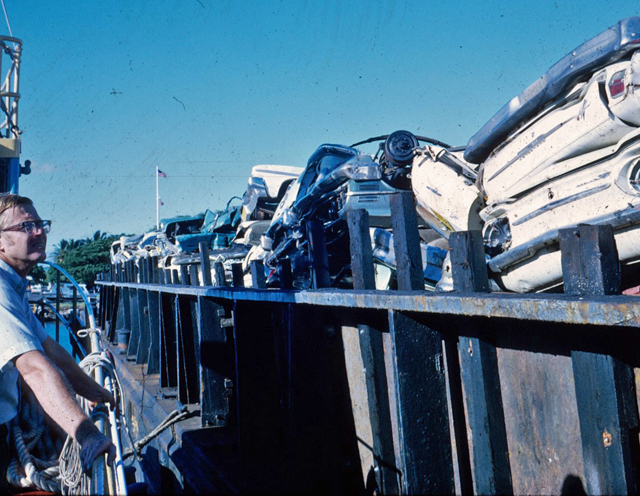 Biologist inspecting cars on barge for deployment. Oahu. 